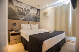 ein Schlafzimmer mit einem großen Bett in einem Zimmer in der Unterkunft Palais Hotel in São Vicente