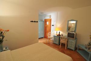 a bedroom with a bed and a mirror and a tv at Hotel Il Piccolo Golf in Porto Cervo