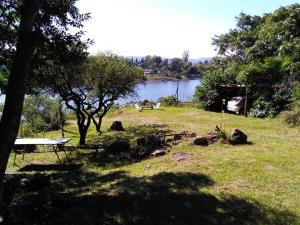 a picnic table in a field next to a lake at El Chaparral in Potrero de Garay
