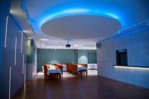 a dining room with tables and chairs and a blue ceiling at Motel Skalka in Radola