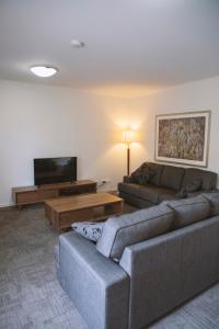 a living room with two couches and a flat screen tv at Quest Wagga Wagga in Wagga Wagga