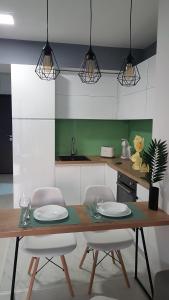 uma cozinha com mesa e cadeiras com pratos em BS Apartment Flatiron em Skopje
