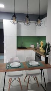 a kitchen with a table and chairs with plates on it at BS Apartment Flatiron in Skopje