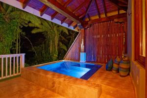 
a room with a pool and a tub at Sleeping Giant Rainforest Lodge in Belmopan
