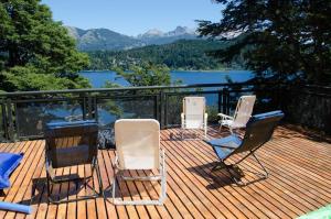 three chairs on a deck with a view of a lake at Albanta casa con costa en Bariloche in San Carlos de Bariloche