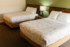 ein Hotelzimmer mit 2 Betten und einer Lampe in der Unterkunft Brown County Inn in Nashville