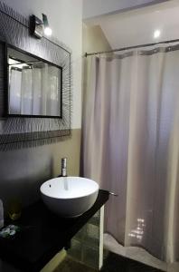 a bathroom with a white sink and a shower at Green Sanctuary Hotel in Nosara