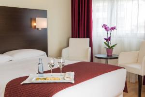 Habitación de hotel con cama y bandeja de comida y copas de vino en Hotel Santiago Apóstol, en Santiago de Compostela