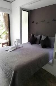 a bedroom with a large bed with a white ribbon on it at Green Sanctuary Hotel in Nosara