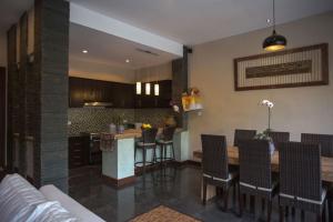 a kitchen with a counter and a bar with chairs at Harum Sari Ubud Private Villa in Ubud