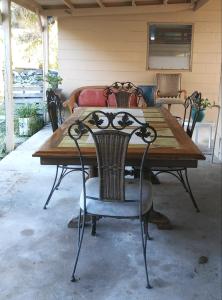 a wooden table with chairs around it on a patio at 1 Beige Cozy Bungalow or 1 White Cozy Efficiency Cottage in Titusville in Titusville