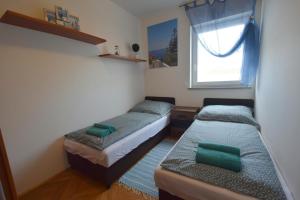 2 łóżka w małym pokoju z oknem w obiekcie Apartment Adlitika w mieście Malinska
