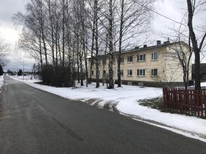 una calle vacía con un edificio, árboles y nieve en Soelaane 12 Apartments, en MikitamÃ¤e