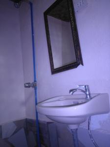 uma casa de banho com um lavatório branco e um espelho. em Overview Hostel em Loon