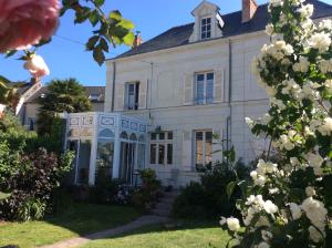 a large white house with flowers in front of it at Les Orkys De Loire in Chalonnes-sur-Loire