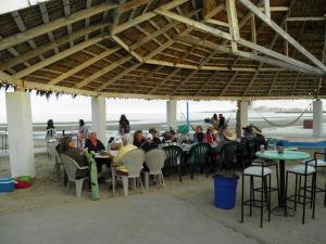 a group of people sitting at tables on the beach at #52 Bungalow Seaside Hotel & Victors RV Park in San Felipe