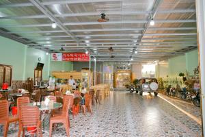 a dining room with tables and chairs in a restaurant at Nhà Nghỉ Quê Ló in Long Hai