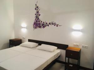 1 dormitorio con 2 camas y una pintura floral en la pared en Visakha 6, en Colombo