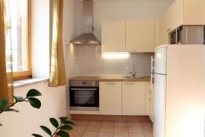 cocina con armarios blancos y nevera en Peaceful Apartment Ankaran SP, en Ankaran