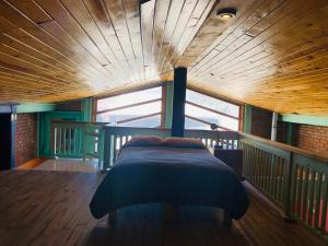 a bed in a room with a wooden ceiling at Departamento tipo cabaña en Creel in Creel