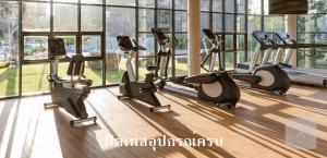 a row of exercise bikes in a gym with windows at Rain ChaAm-HuaHin JN in Cha Am