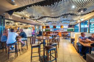 a group of people sitting at tables in a restaurant at Narrabeen Sands Hotel by Nightcap Plus in Narrabeen