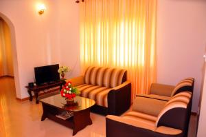 a living room with a couch and two chairs and a table at Senero House in Bentota