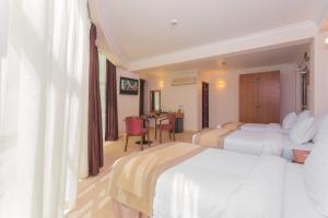 A bed or beds in a room at Champa Central Hotel