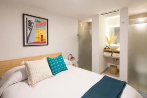 a bedroom with a white bed with a blue pillow at Hotel Casona Independencia in Guadalajara