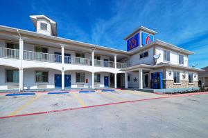 een groot wit gebouw met een parkeerplaats bij Motel 6-Rhome, TX in Rhome