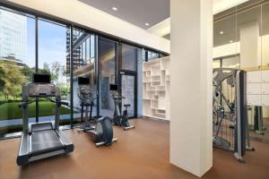 a gym with cardio equipment in a building with windows at Days Hotel by Wyndham Singapore at Zhongshan Park in Singapore
