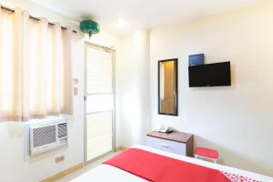 a bedroom with a red bed and a tv at Starlight Bed and Breakfast in Manila