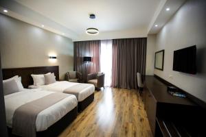 a hotel room with two beds and a television at Crystal Hotel & SPA in Bakuriani