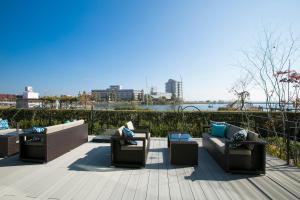 a group of couches sitting on a deck with a view of the water at Biwako Ryokusuitei in Otsu