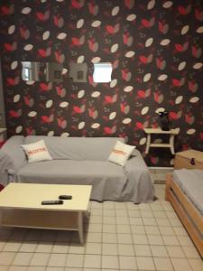 une chambre avec un canapé et un mur avec des cœurs dans l'établissement Gite "Etape à Coucy", à Coucy-le-Château-Auffrique