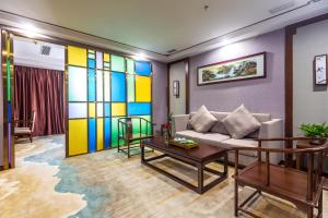 uma sala de estar com um sofá e uma parede colorida em Guangzhou Nan Guo Hotel em Guangzhou