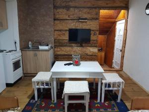 a kitchen with a white table and two chairs at Apartments Javorje Zabljak in Žabljak