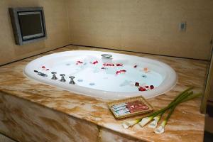 eine Badewanne mit roten Blumen auf der Theke in der Unterkunft Crystal Business Motel in Hsinchu
