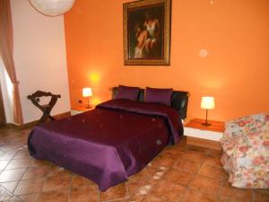 a bedroom with a purple bed and a couch at B&B Casa Tua in Naples