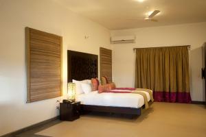 a bedroom with a bed and a window at Niraamaya Wellness Retreats, Surya Samudra, Kovalam in Kovalam