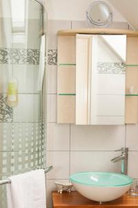uma casa de banho com um lavatório e uma cabina de duche em vidro. em Biohof - Familie Neuberger em Pöttelsdorf