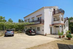 two cars parked in front of a house at APARTMAN KATY in Šilo