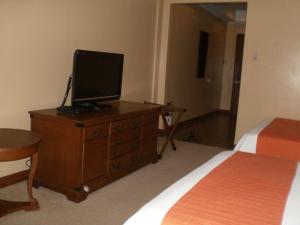 ein Schlafzimmer mit einer Kommode mit einem Fernseher drauf in der Unterkunft PRIVATE unit CAMP JOHN HAY MANOR in Baguio City