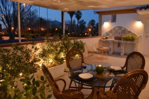 un patio con mesa, sillas y luces en Valuan Luxury Home, en Palermo