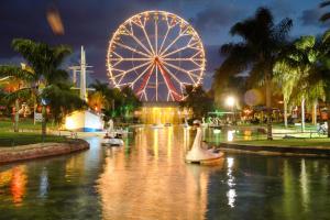 a ferris wheel and boats in a river at night at Spat Business Holon in H̱olon