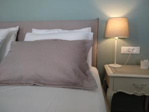 a bed with a pillow and a table with a lamp at Yalitzi in Symi