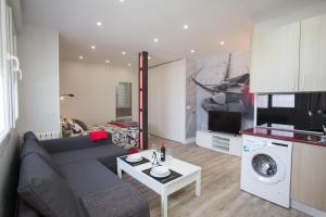 uma sala de estar com um sofá, uma mesa e uma cozinha em WindRose 9 em Madri