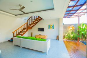 a living room with a couch and a staircase at Sun Shoot Villas Seminyak in Seminyak