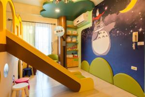 une chambre pour enfants avec un escalier et une fresque murale représentant un monstre dans l'établissement Misto B&B, à Taïtung