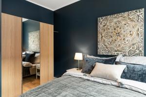 a bedroom with a bed and a large mirror at Høyden Apartments in Bergen